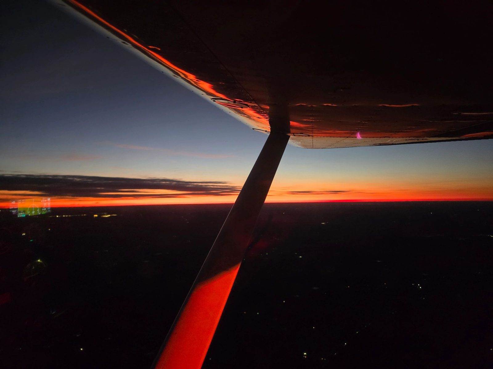Sunset seen from the wing of a Kingdom Planes aircraft in flight